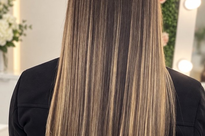 Cabelo castanho longo com mechas iluminadas e finalização lisa